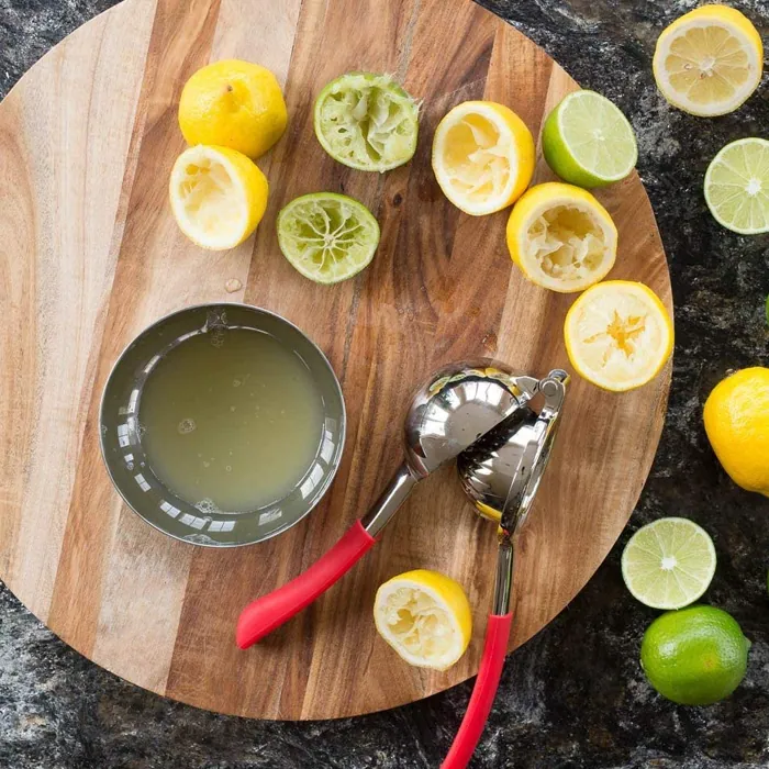 A citrus squeezer on a board with limes: the hinge we changed twice.